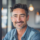 Homme souriant dans un café moderne.